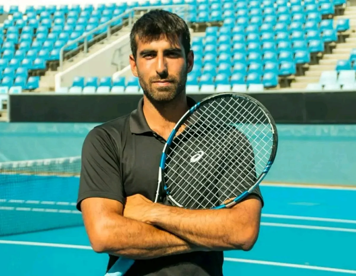 Andy Gomez with a tennis racket
